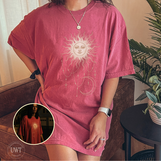 Comfort Colors unisex tee featuring a celestial sun face, hanging stars, and crescent moon, inspired by Patricia’s shirt in Widow’s Bay.