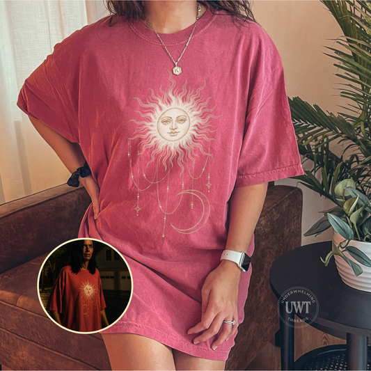 Comfort Colors unisex tee featuring a celestial sun face, hanging stars, and crescent moon, inspired by Patricia’s shirt in Widow’s Bay.
