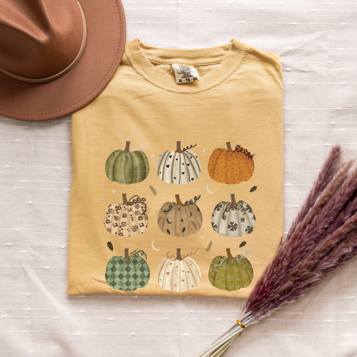 Mustard Comfort Colors T-shirt featuring an original hand-drawn pumpkin mage illustration in muted boho watercolor tones.