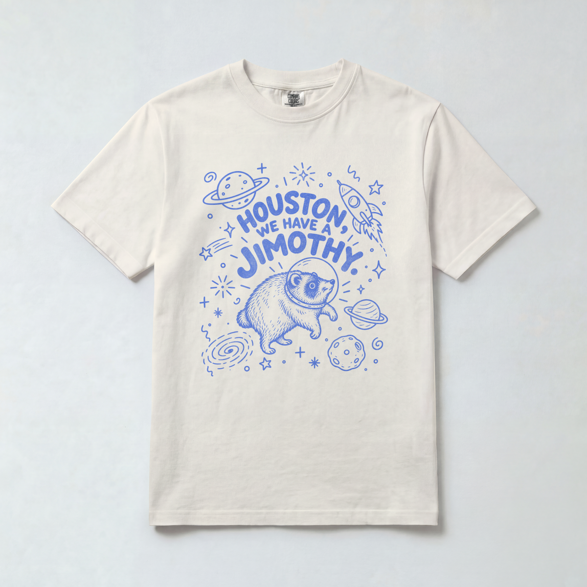 Comfort Colors 1717 unisex tee with blue “Houston, We Have a Jimothy” lettering and a raccoon in a space helmet surrounded by planets, stars, and a rocket.