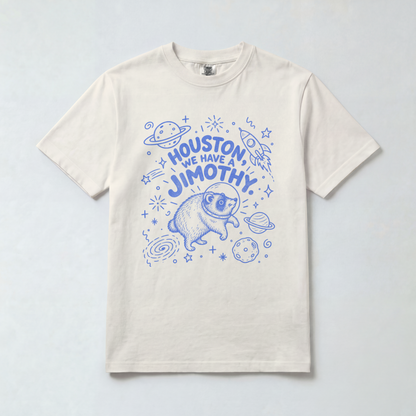 Comfort Colors 1717 unisex tee with blue “Houston, We Have a Jimothy” lettering and a raccoon in a space helmet surrounded by planets, stars, and a rocket.